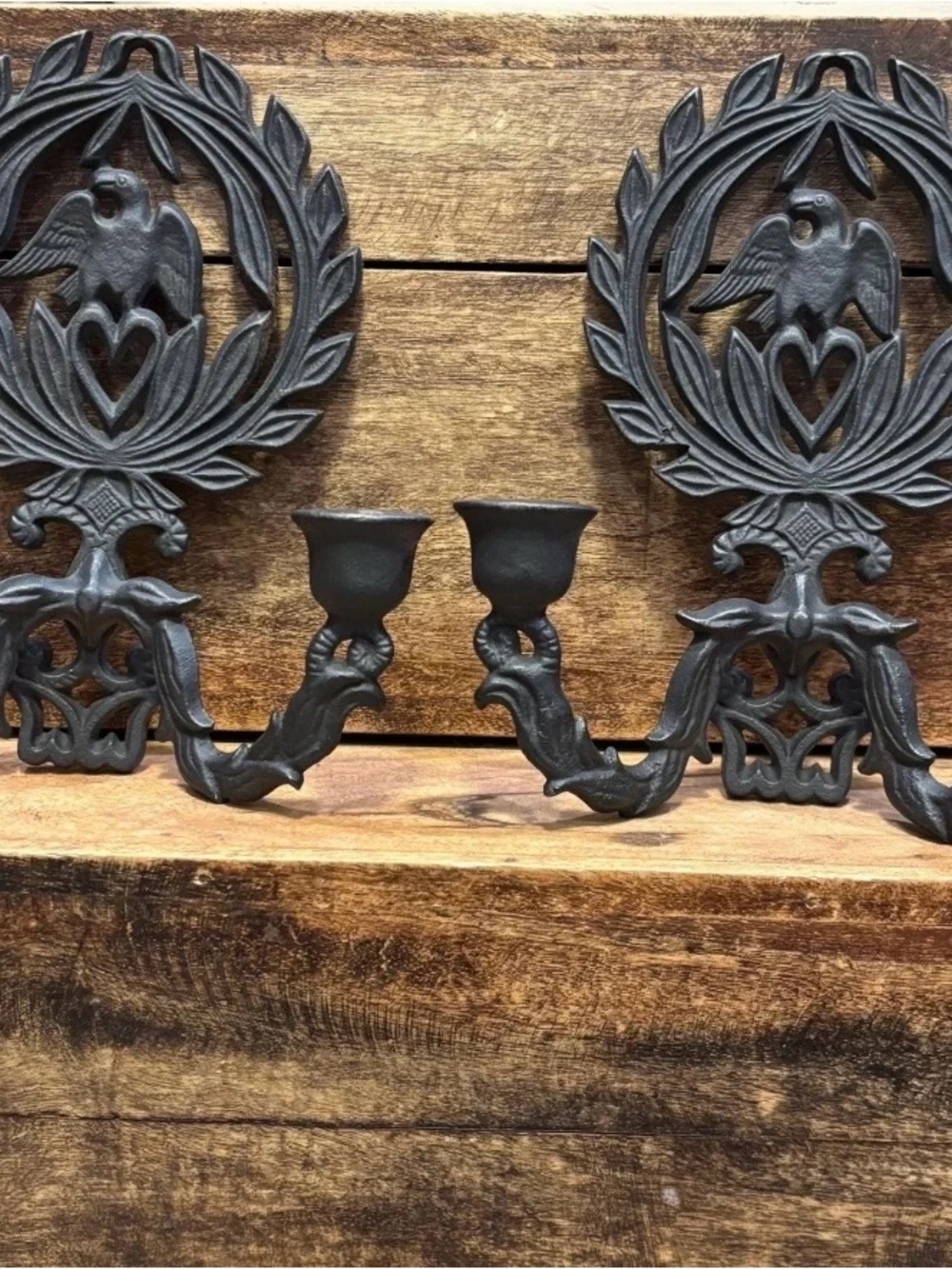 A pair of vintage cast iron wall sconces with eagle and laurel wreath motif